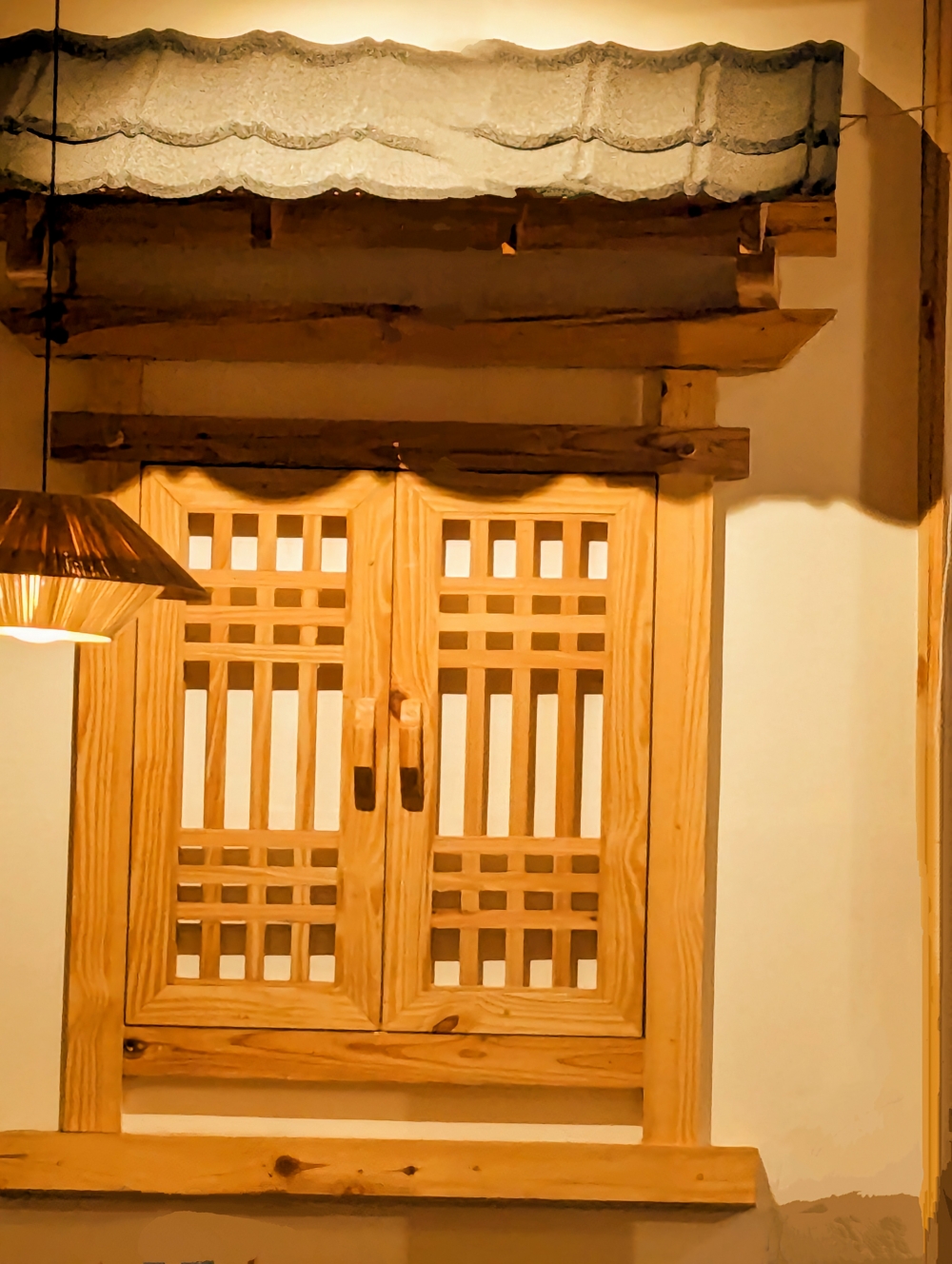 Traditional Wooden Window Design, window frame, scalloped valance, warm pendant lighting, natural wood grain, plaster wall contrast, traditional joinery, decorative window feature, ambient light shadows, handcrafted window design